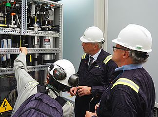 Staatssekretär Roland Weigert (M.) und Prof. Peter Wasserscheid (r.) bei der Besichtigung des ersten Elektrolyseurs für grünen H2 in Kolumbien. Die Anlage steht in der Ecopetrol-Raffinerie in Cartagena (Foto: StMWi)